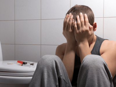 man in bathroom with drugs who needs mental health and addiction recovery treatment
