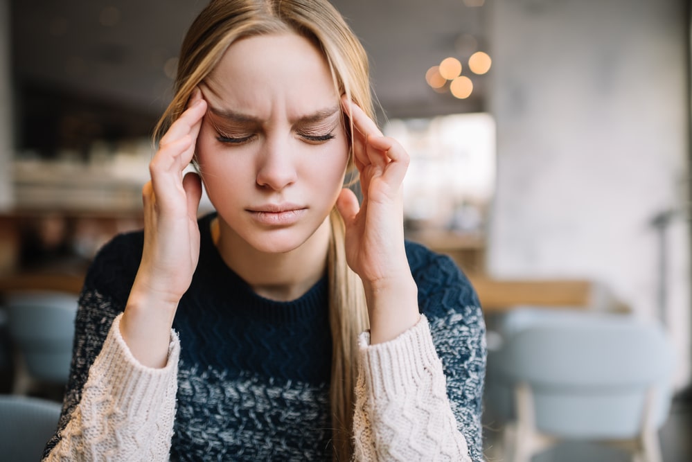 Alcoholism withdrawal symptoms - woman having a headache