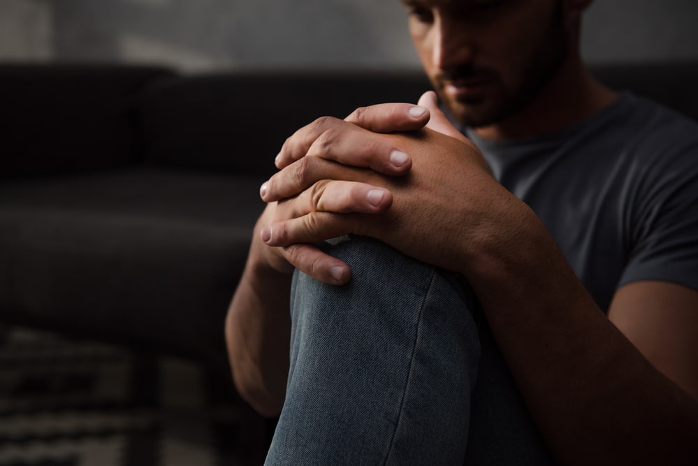 alcoholism symptoms - man sitting on the floor