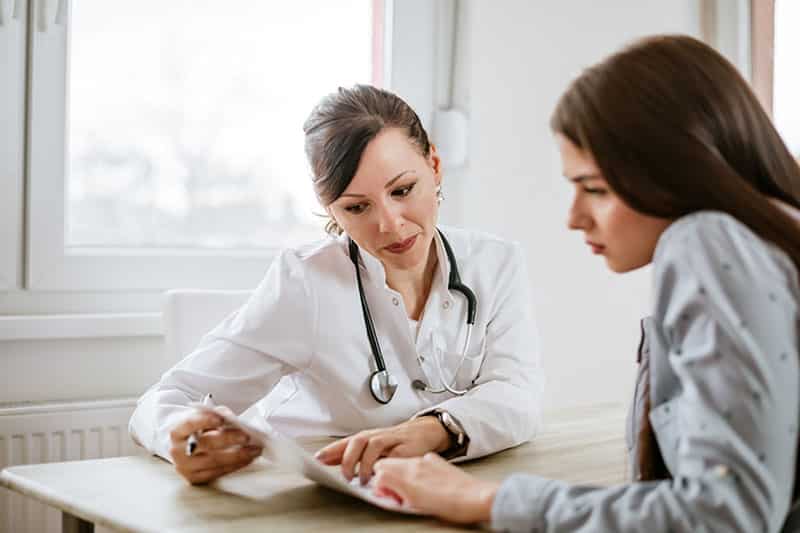 Doctor discussing health insurance coverage of medical detox to her young patient.