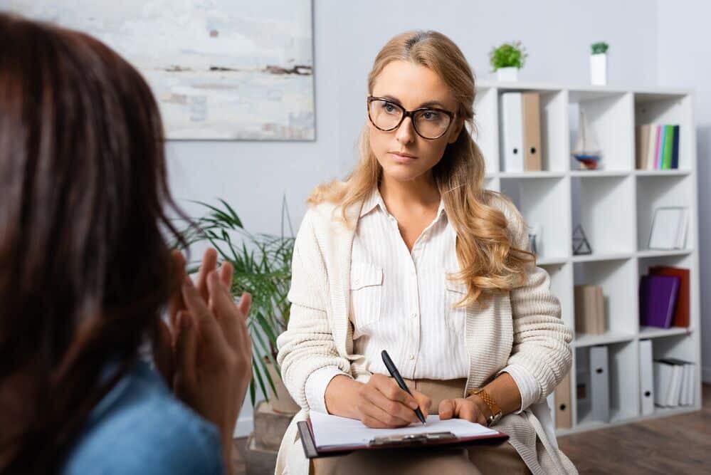 therapist speaking to a patient to determine undiagnosed mental health disorders