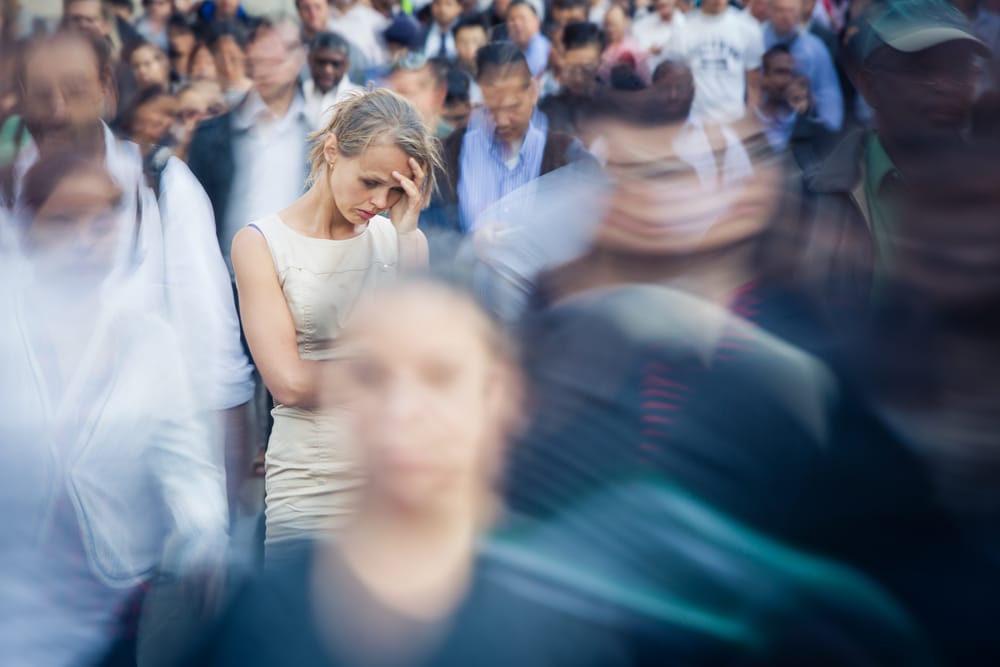 lady experiencing anxiety mental health disorder in a crowd of people