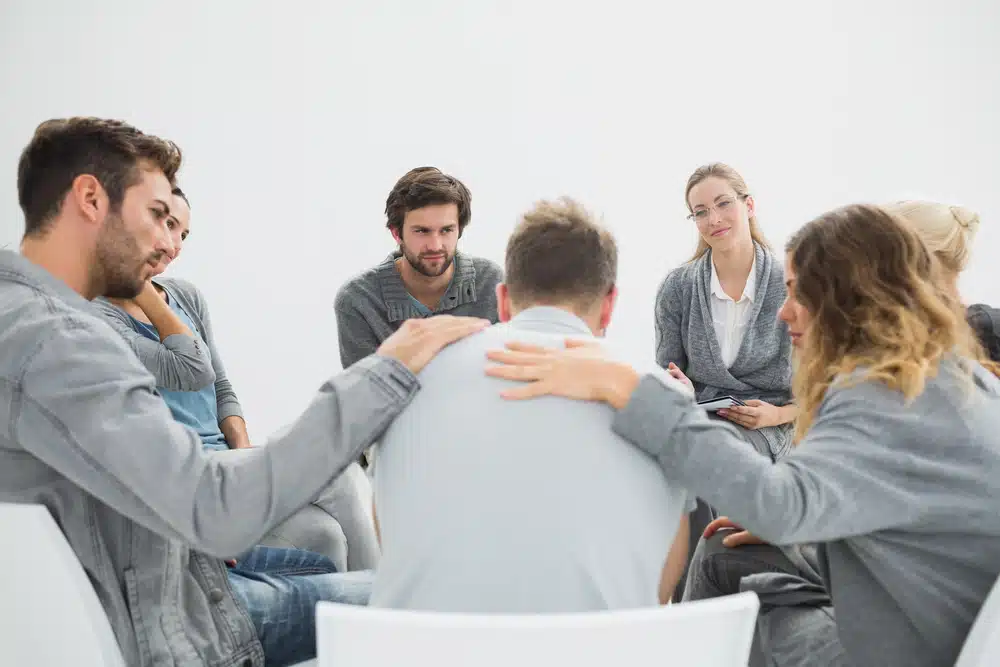 Group therapy in session sitting in a circle with therapist group sessions as part of the treatment process of a PHP treatment center near Fort Pierce, FL