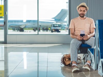 man in airport deciding should I travel for rehab?
