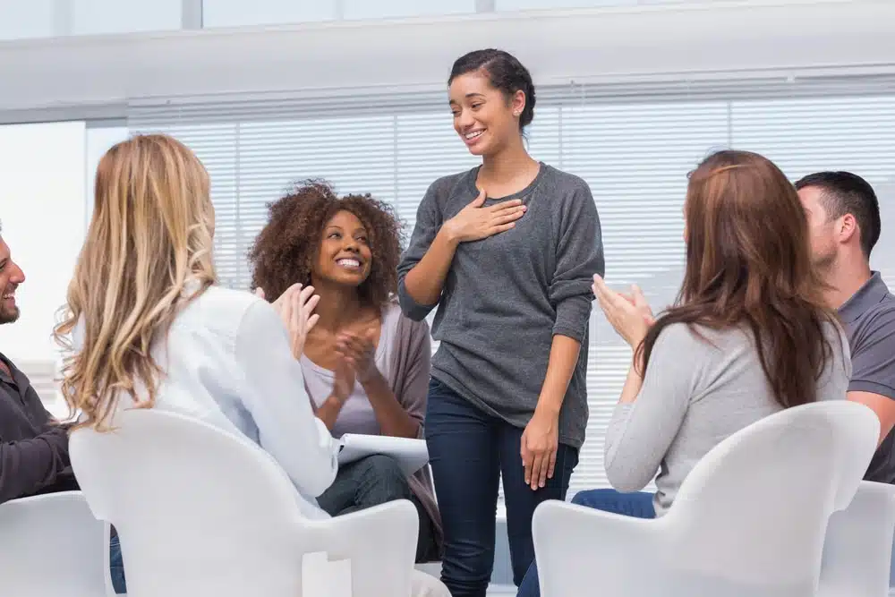 group-therapy-1 happy woman in front of group that just completed our benzo rehab program in Florida