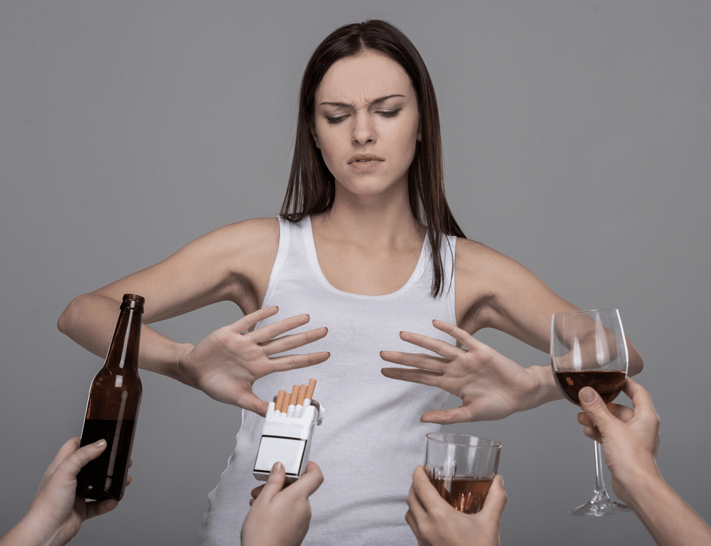 woman saying no to alcohol and other environmental factors that can lead to addiction