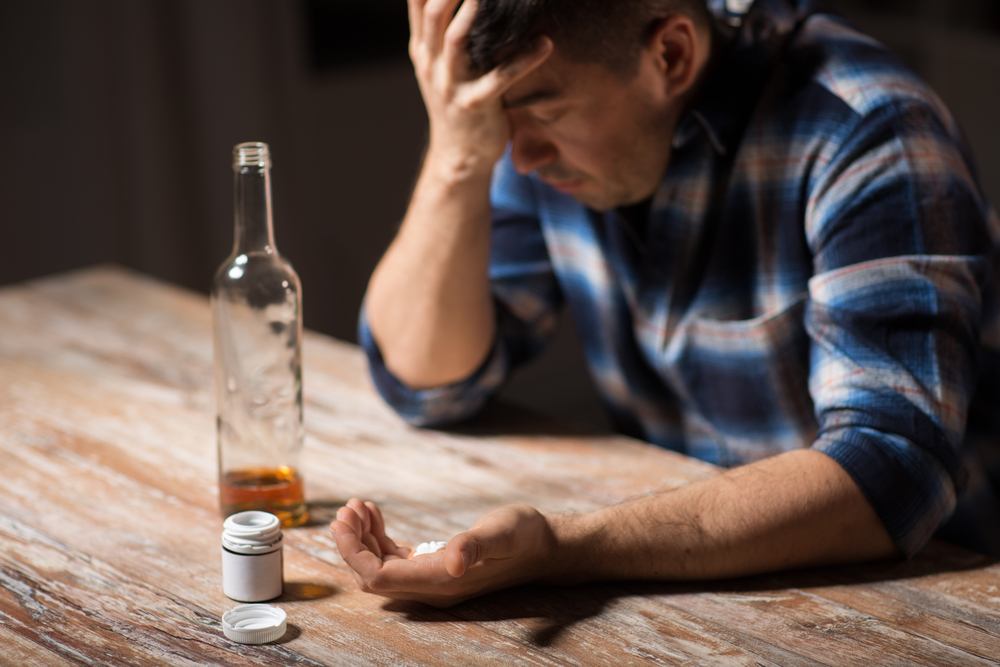 man experiencing depressive symptoms uses alcohol to deal with it