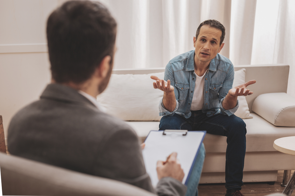 psychiatrist discussing the three phases of alcoholism to alcoholic man