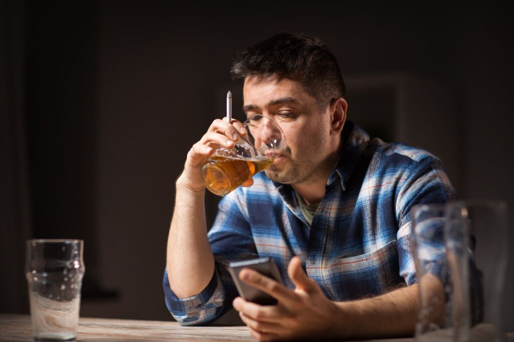 man searching how to get into alcohol rehab but still drinking