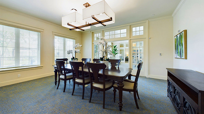 a well lit conference room with a big table and 8 chairs