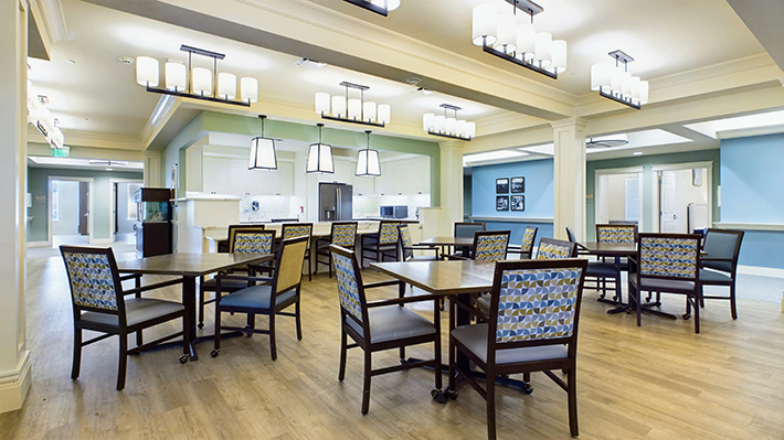 a very pleasant dining hall and kitchen with attractive blue and green walls.