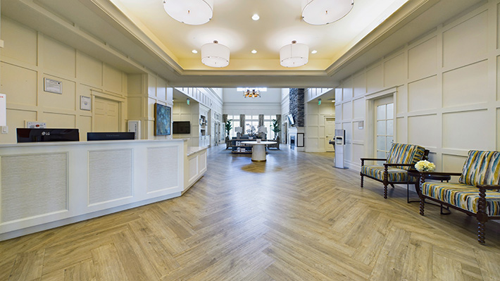 a large lobby area with couches and lots of sunlight.