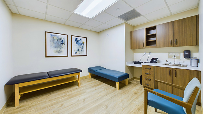 a cozy version of a medical office with massage benches and a sink.