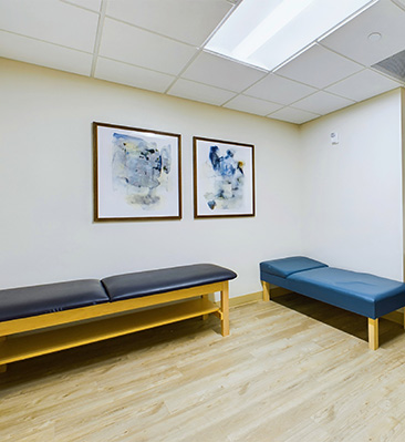 a massage room with 2 massage benches and 2 paintings